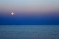 Red Moon and blue sea at nightfall