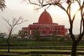 a red mosque building with an interesting architecture stands in the middle of rice fields Royalty Free Stock Photo