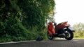 The red motorbike on forest road trail trip. One scooter, near tropical palm tree. Asia Thailand ride tourism. Single Royalty Free Stock Photo