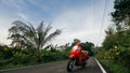 The red motorbike on forest road trail trip. One scooter, near tropical palm tree. Asia Thailand ride tourism. Single Royalty Free Stock Photo