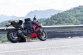 Red motorcycle modern style parked on road with mountain view background and copy space