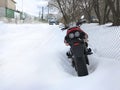 Red motorcycle stands in a snowy parking lot covered in snow in winter Royalty Free Stock Photo