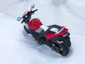 Red motorcycle stands in a snowy parking lot covered in snow in winter Royalty Free Stock Photo