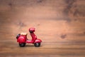 Red motorcycle vespa on old and vintage rustic wooden background