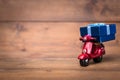 Red motorcycle vespa are Transporting Blue gift box on old and v Royalty Free Stock Photo