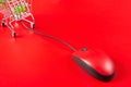 Red mouse connected to shopping cart on red background Royalty Free Stock Photo