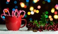 Red mug with candy canes in snow with defocussed fairy lights, bokeh Royalty Free Stock Photo