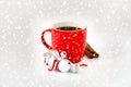 Red Coffee Mug with Jingle Bells, Cinnamon Sticks and Snowfall Royalty Free Stock Photo