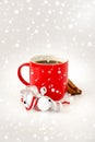 Red Coffee Mug with Jingle Bells, Cinnamon Sticks and Snowfall Royalty Free Stock Photo