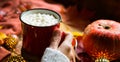 Red mug hot chocolate with marshmallows on table with maple leaves, garlands, cinnamon sticks. Autumn atmosphere, warming coffee, Royalty Free Stock Photo