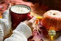 Red mug hot chocolate with marshmallows on table with maple leaves, garlands, cinnamon sticks. Autumn atmosphere, warming coffee, Royalty Free Stock Photo