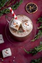 Red mug with hot chocolate and melted marshmallow snowman, red festive background