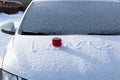 A red mug with a hot drink on a snowy car hood on a bright winter sunny day. The inscription on the snow is love Royalty Free Stock Photo