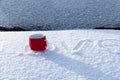 A red mug with a hot drink on a snowy car hood on a bright winter sunny day. The inscription on the snow is love Royalty Free Stock Photo