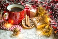 Red mug with tea in Christmas decorations on a white knitted blanket. New year, garlands, gifts, cinnamon and dried orange - an at Royalty Free Stock Photo