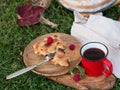 A red mug of tea or strong coffee stands next to a slice of homemade pie