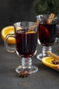 Red mulled wine in glasses at black background. Fir wreath, orange, cinnamon, nuts, cone and spices Royalty Free Stock Photo