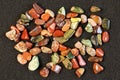 Red and multicolored jasper polished tumblestones on black background