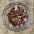 Red and multicolored jasper polished tumblestones in glass plate on rough linen background