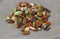 Red and multicolored jasper polished tumblestones on light grey background Narrow focus line, shallow depth of field