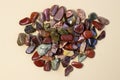 Red and multicolored jasper polished tumblestones on light beige background