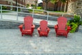 3 red Muskoka chairs on the street in Cottage Country, Ontario