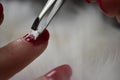 Red nail manicure christmas stickers putting with tweezers