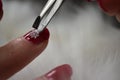 Red nail manicure christmas stickers putting with tweezers