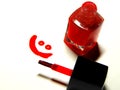 Red nail polish, brush and a smiley face