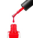 Red nail polish dripping from brush into bottle closeup Royalty Free Stock Photo