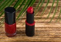 Red nail polish and red lipstick on a wooden burnt background Royalty Free Stock Photo