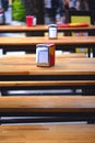 Red napkin ring among many wooden tables