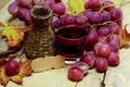 Red natural jucie homemade wicker bottle and grapes Royalty Free Stock Photo