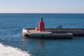 Red navigational light on a breakwater at a port