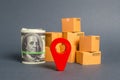 Red navigational location designator, cardboard boxes and a Roll bundle of dollars. Business and commerce. Local economy