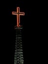 Red neon cross at night