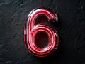 A red neon number six on a black wall Royalty Free Stock Photo