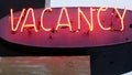 Red neon sign Vacancy glowing, motel or hotel, California USA. Illuminated text.