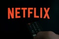 Red NETFLIX Company Logo On A TV Set And Remote Control