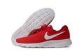 Red Nike brand sneakers. Lightweight reticulate shoes for jogging and walking. Popular modern model for fitness and