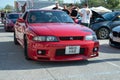 red ninth-generation Nissan Skyline GT-R33 at a Japanese sports car meet.