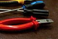 Red nippers pruning cable crimping power strip screwdriver closeup background industrial equipment Royalty Free Stock Photo