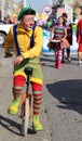 Red-nosed clown pedaling unicycle. Royalty Free Stock Photo