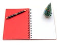 Red notebook with pen and mini christmas tree Royalty Free Stock Photo