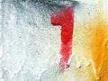 Red number one painting or spraying on the white, yellow, and black concrete wall with copy space Royalty Free Stock Photo