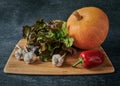 Red oak salad, pumpkin, garlic and sweet pepper, vegetables on a cutting wooden board