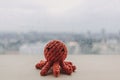 Red octopus knitting handmade toy doll on wooden desk with copy space.