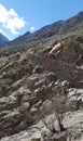 A red off-road car climbing up mountain on a dangerous rocky road