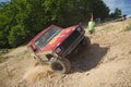 Red offroad car is in great lateral tilt