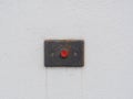 Red old alarm button on the white cement wall. Service accessible entrance sign. Help call button for people Royalty Free Stock Photo